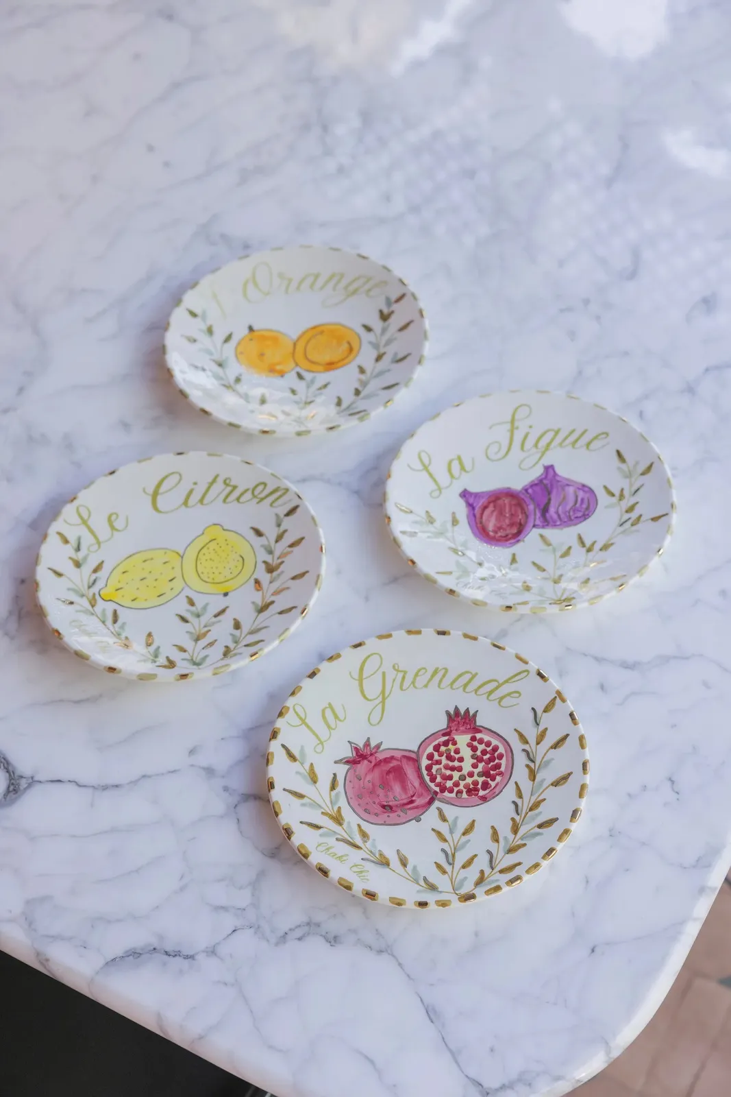 Lot de quatre assiettes moyennes en céramique décor fruit citron orange figue grenade